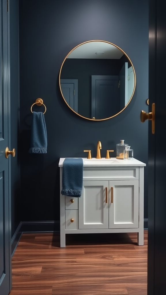 A stylish half bathroom featuring navy walls, a white vanity with brass fixtures, a circular brass-framed mirror, and wooden flooring.