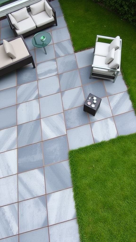 A contemporary geometric paver patio with grey pavers and green grass, featuring comfortable outdoor furniture.