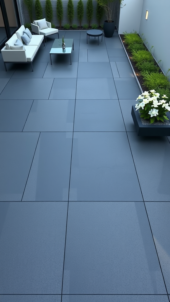 A modern linear paver patio with large grey tiles, a seating area, and planters.