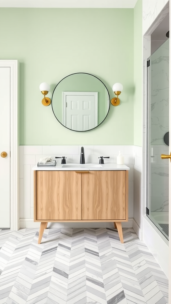 A modern bathroom featuring soft green walls, a marble herringbone floor, a wooden vanity, and stylish light fixtures.